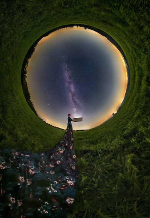 a person standing in a field looking at the stars
